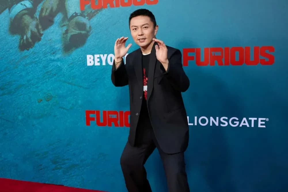 Xie Miao in a fight scene, mid-movement, wearing a dark jacket and focused expression