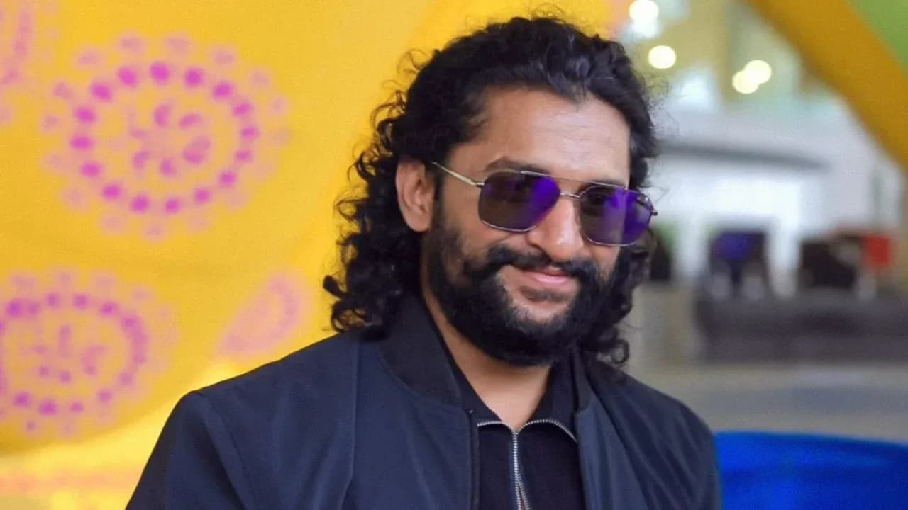 Nani in a casual outfit, smiling at a press event, holding a script.