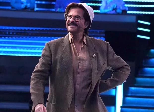 Anil Kapoor in his Mr. India outfit, standing in front of a stage with a golden 'Top 1%' logo