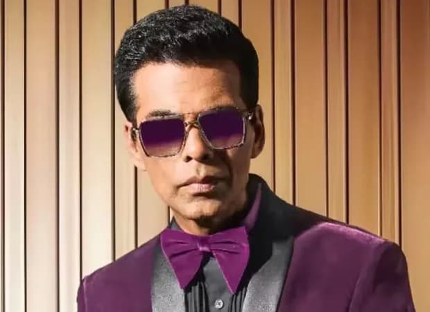 Karan Johar smiling at a public event, representing his rise on the Hurun India Rich List
