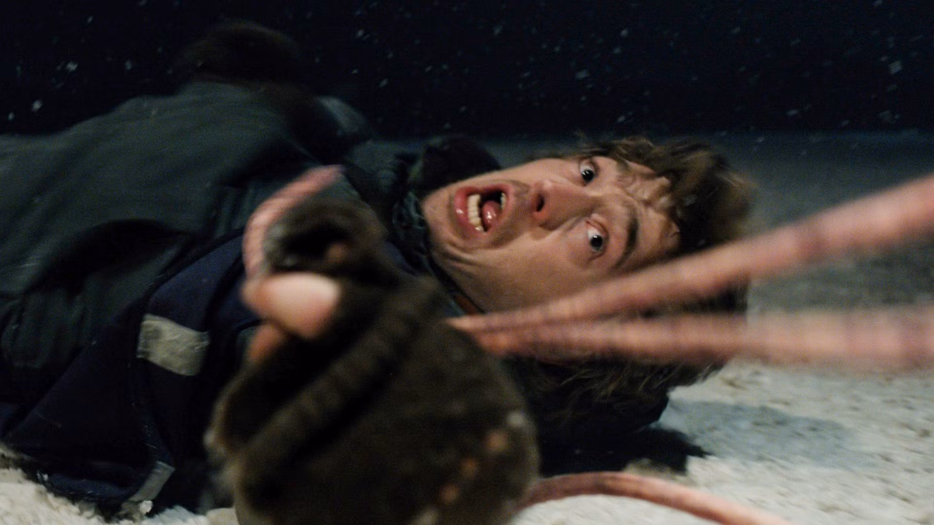 A still from Resident Evil (2026), showing Austin Abrams as Bryan in a dark, zombie-filled cityscape.