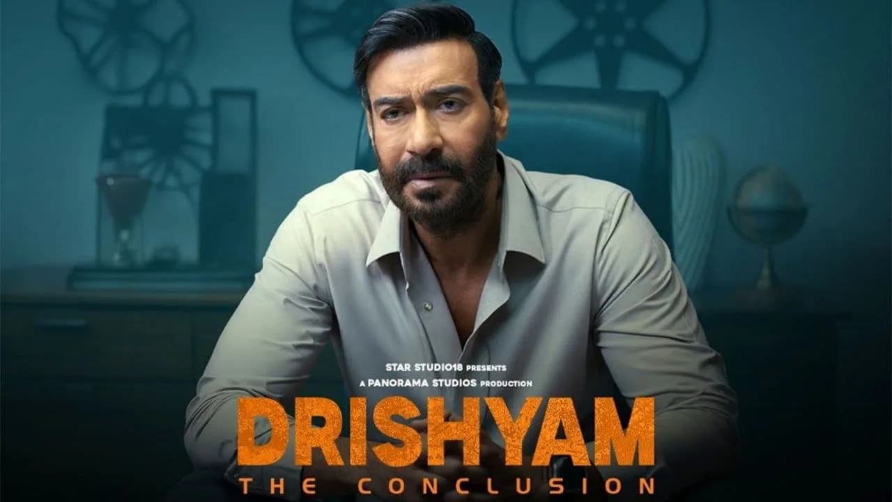Ajay Devgn in Drishyam: The Conclusion, standing in front of a city skyline at night, looking intense.