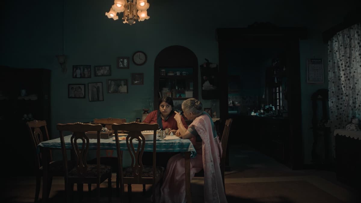 A still from the short film Olakh showing two women in a domestic kitchen setting.