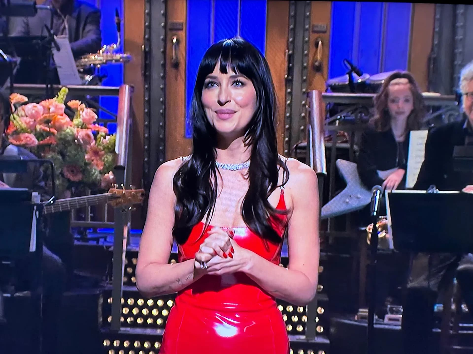 Taylor Swift and Dakota Johnson laughing on stage during SNL's opening monologue