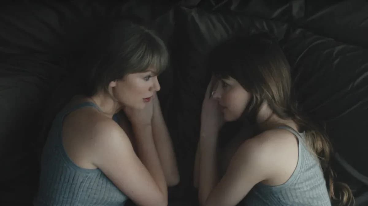 Taylor Swift performing in the Patient Zero music video alongside Dakota Johnson and Colin Farrell, surrounded by symbolic set pieces.