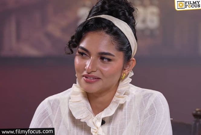 Kayadu Lohar standing on a set with a microphone, looking focused during The Paradise shoot