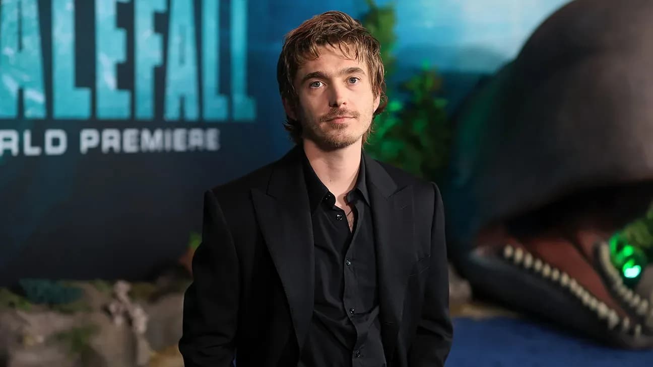 Austin Abrams in a scuba suit, looking tense, standing near a large whale model on a studio set
