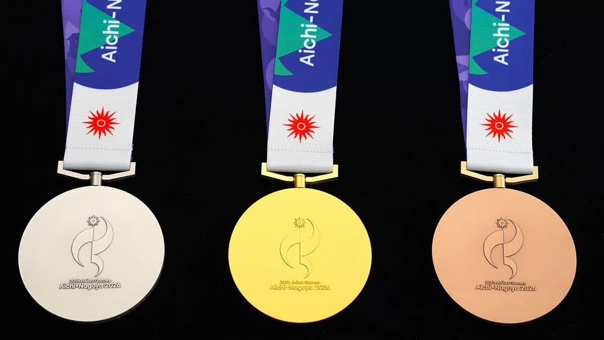 Indian athletes celebrating on the podium at the Asian Games 2026 in Nagoya, with medals around their necks and national flag waving.