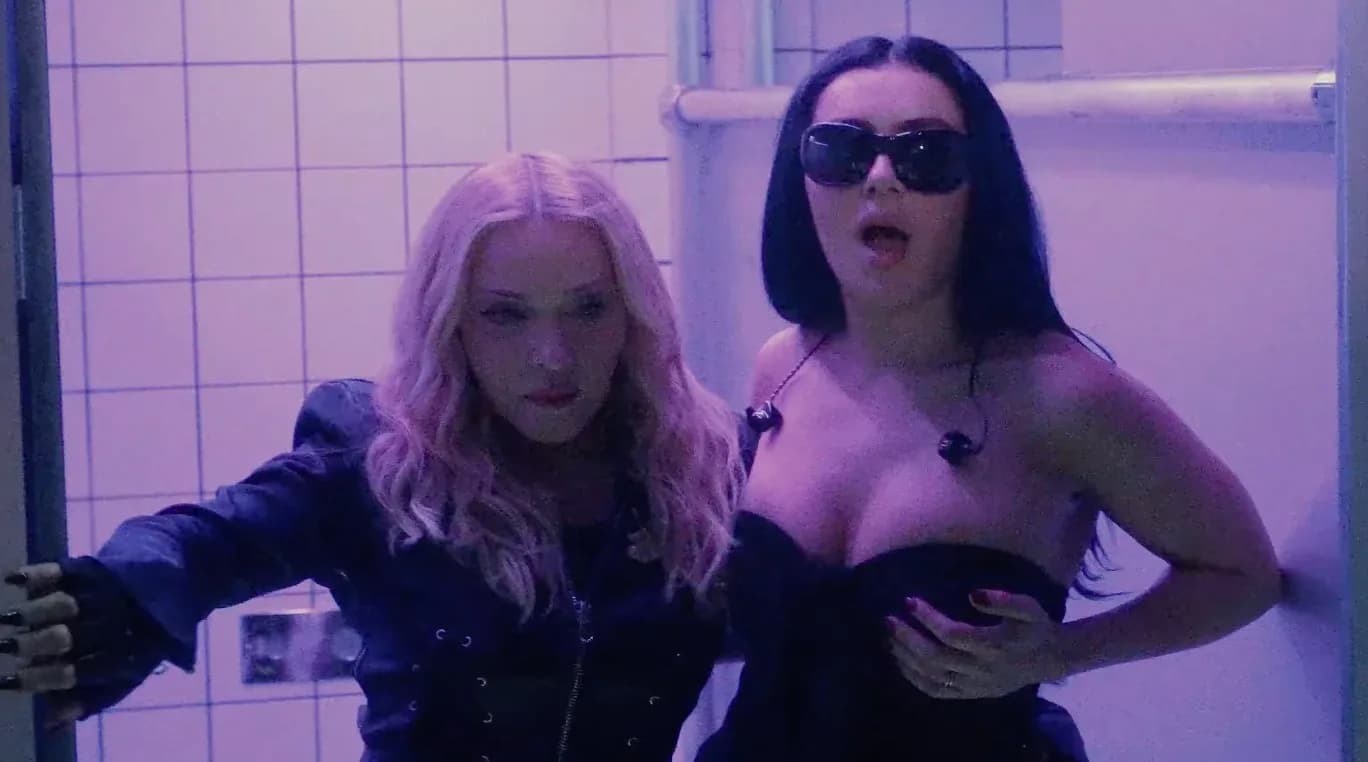 Madonna performing on stage at the 2026 MTV VMAs, surrounded by dancers and flashing lights.