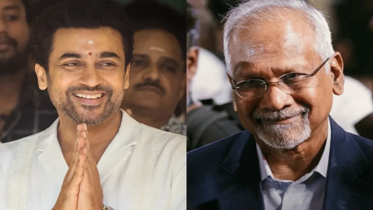 Suriya and Mani Ratnam standing together on a film set, smiling, with a blurred camera crew in the background