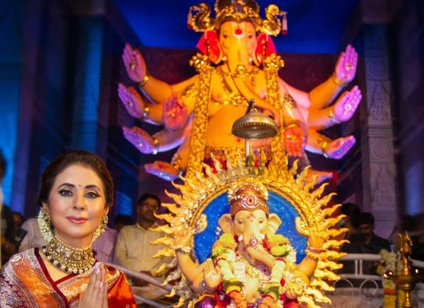 Urmila Matondkar in an orange silk saree with folded hands at a Ganpati pandal in a throwback photograph.