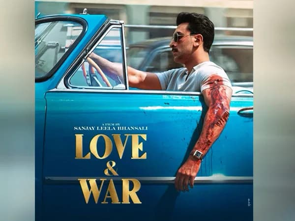 Ranbir Kapoor in character poster for Love & War, seated behind a car's steering wheel with a blood-streaked hand, wearing sunglasses and a moustache.