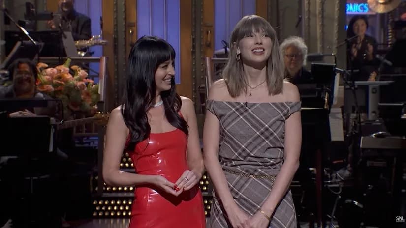 Taylor Swift and Dakota Johnson on stage together during an SNL monologue segment.