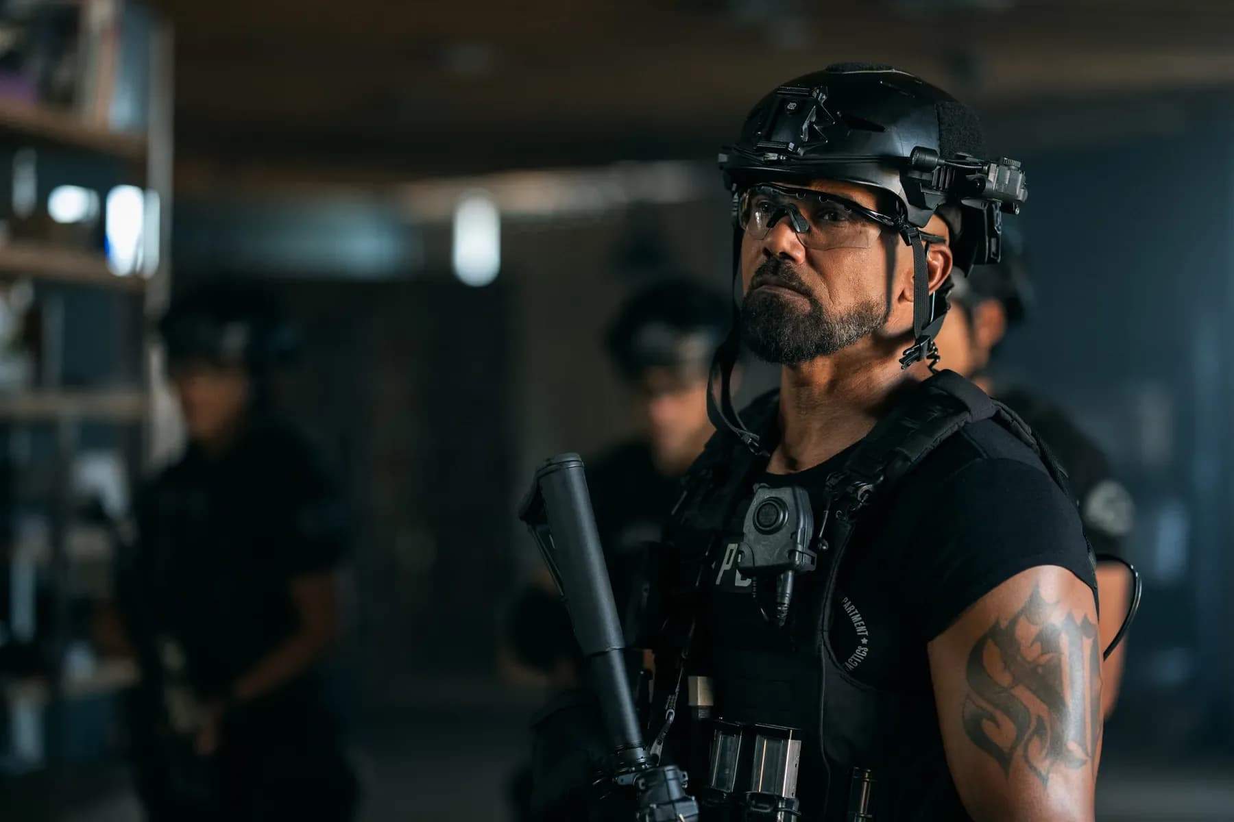 Shemar Moore as Hondo standing with his new S.W.A.T. Exiles team in a Los Angeles precinct hallway