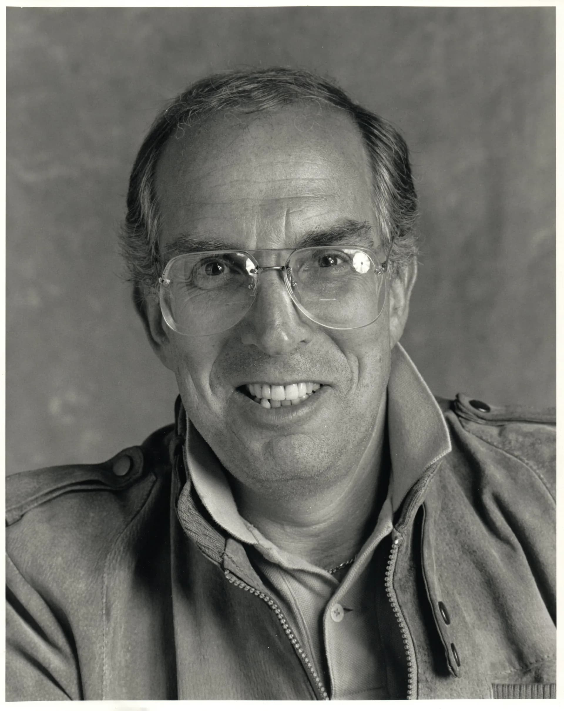 Portrait of Jerry Golod, a white man in his 80s with glasses and a beard, wearing a dark jacket.