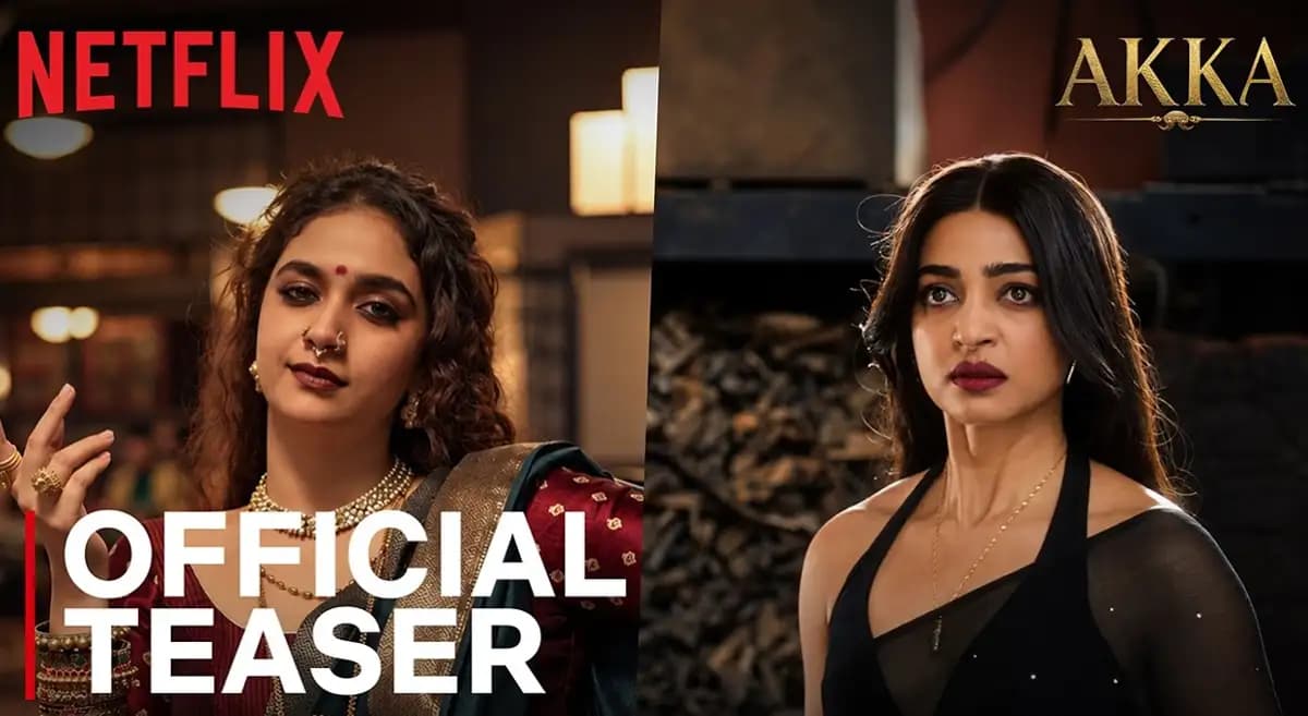 Keerthy Suresh and Radhika Apte in fierce poses, dressed in traditional attire, standing in a dimly lit room with tension in their eyes.