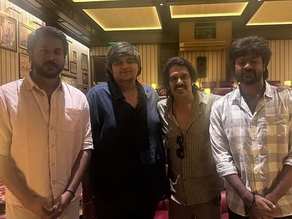 Karthik Subbaraj and Upendra in a candid conversation, smiling at the camera.