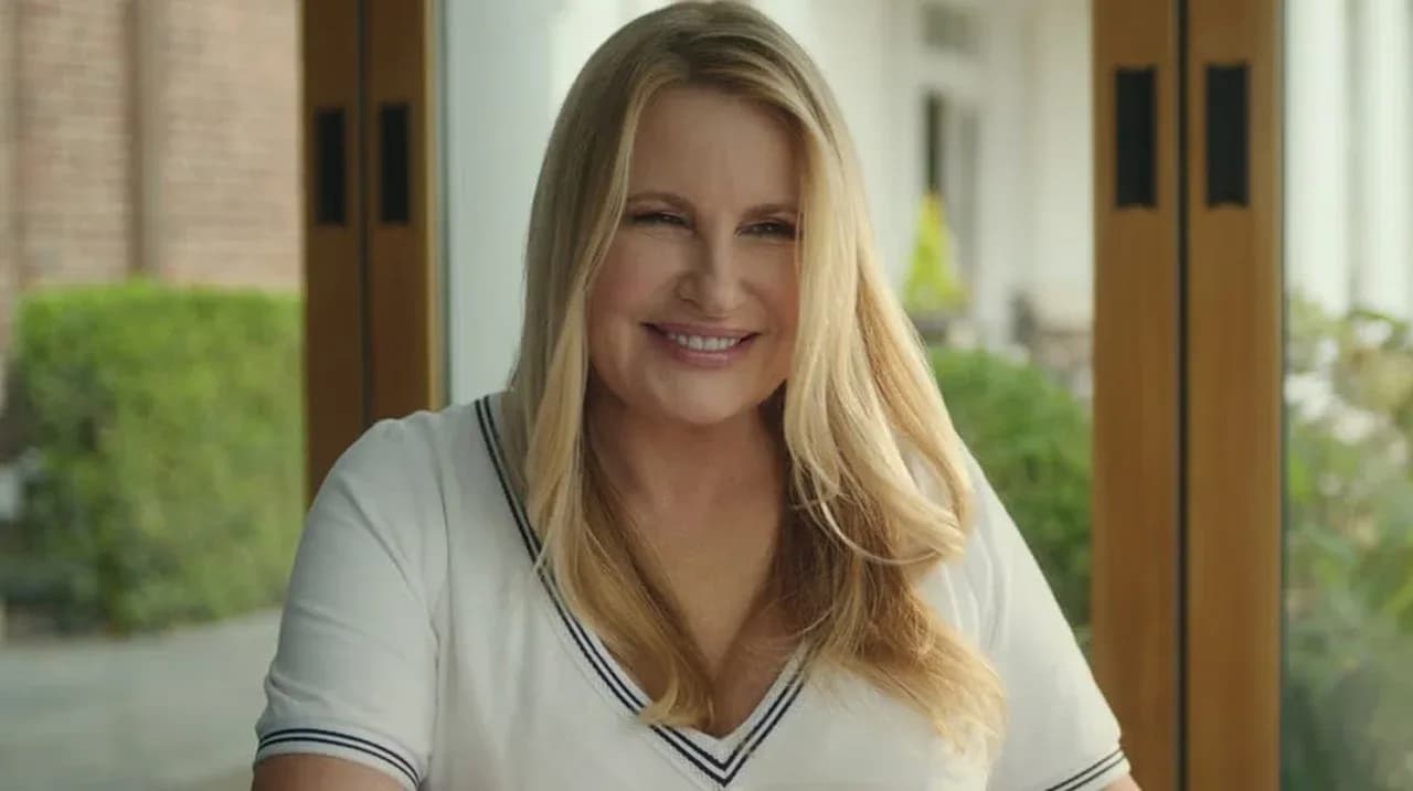 Jennifer Coolidge in a pastel power suit, standing in front of a suburban house with a sinister atmosphere