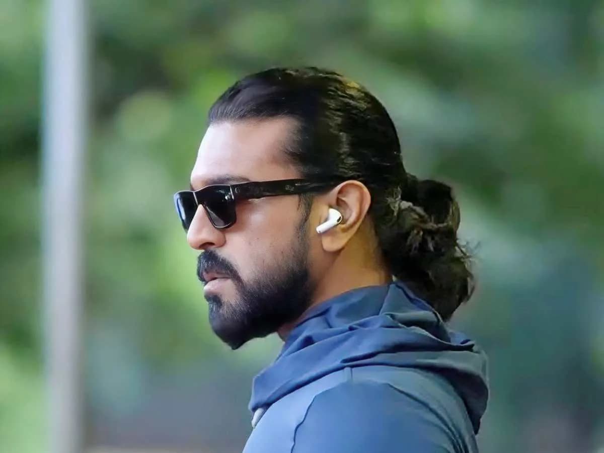 Ram Charan in a lean physique, standing in front of a temple setup, preparing for a pooja ceremony.