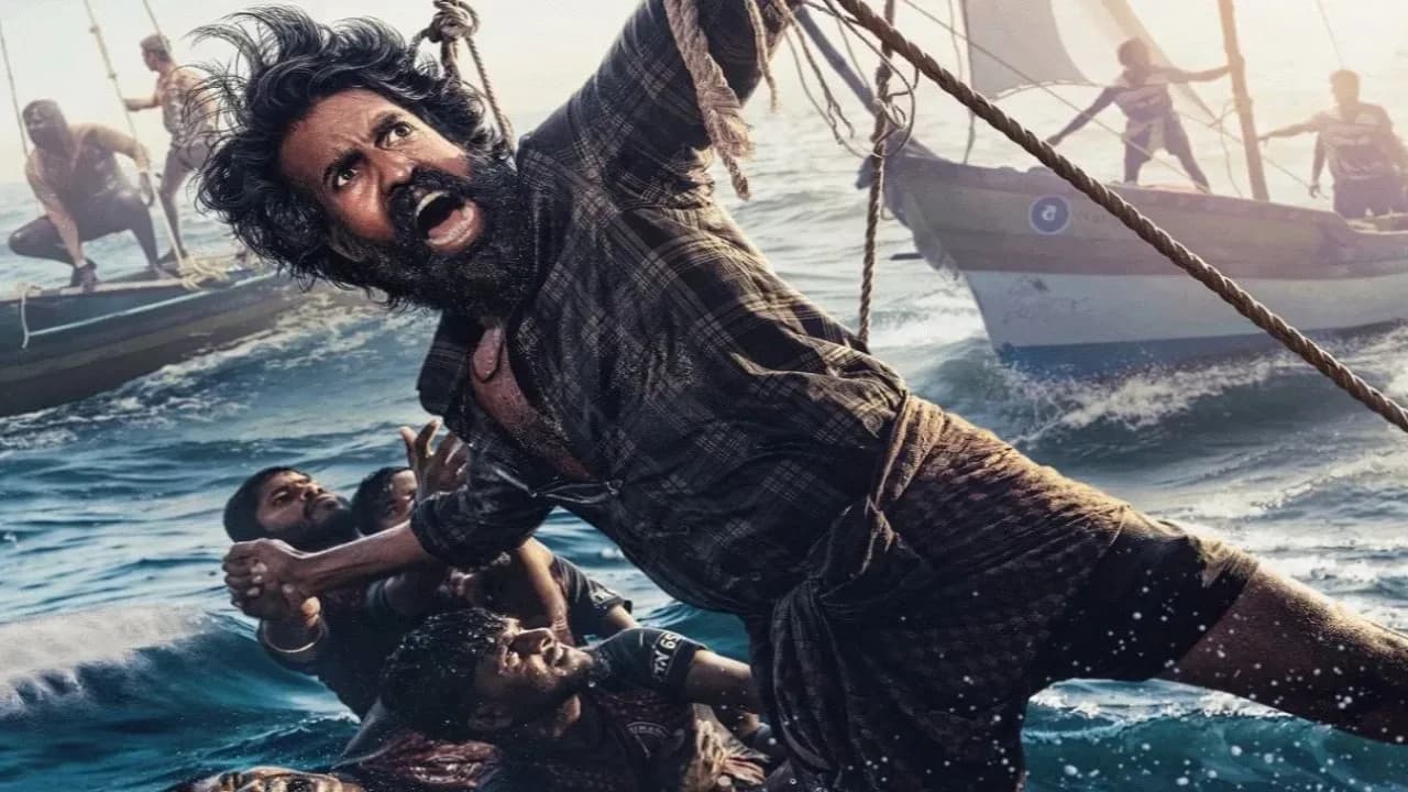 Soori in a still from the Tamil sports drama Mandaadi, standing near a sailboat on the coast