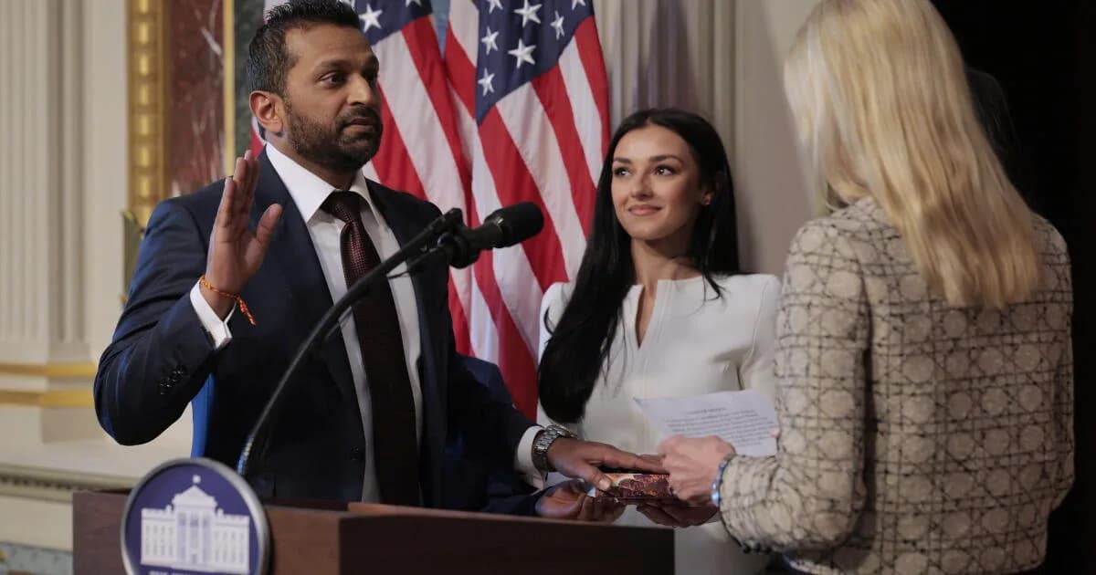 Kash Patel and Alexis Wilkins smiling together, holding hands, with Wilkins showing off her engagement ring in a black-and-white photo.