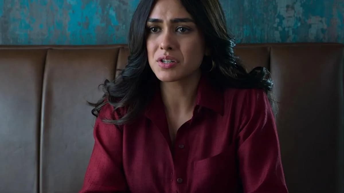 Mrunal Thakur in a tense courtroom scene, face half-lit, eyes sharp with quiet defiance.