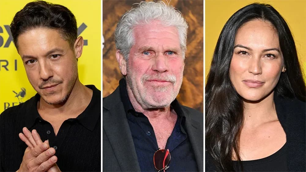 A first-look image from the horror film Renew, showing Theo Rossi and Ron Perlman in a tense, shadowy scene at a remote Montana ranch.
