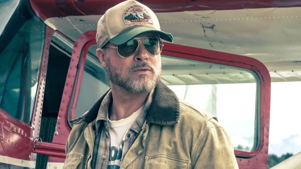 Brad Pitt and his combat dog Odin standing in a snowy Alaskan landscape from Heart of the Beast