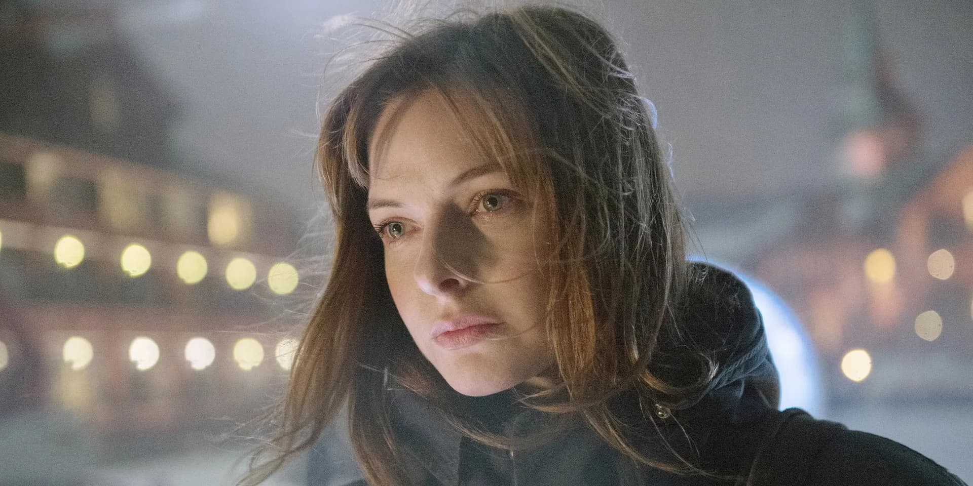 Still from The Snowman featuring Michael Fassbender and Rebecca Ferguson in a dark, snowy urban setting