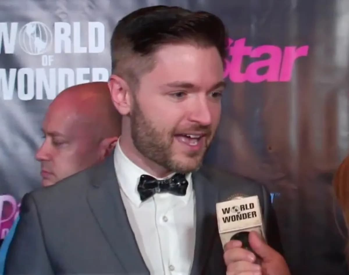A portrait of Lucian Piane, a man with short dark hair and glasses, smiling warmly.