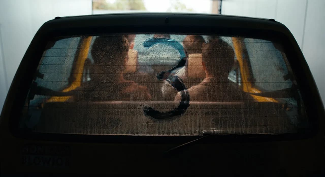 First-look image of the four Inbetweeners actors, older but instantly recognisable, seated in the battered yellow Fiat Cinquecento from the original series.