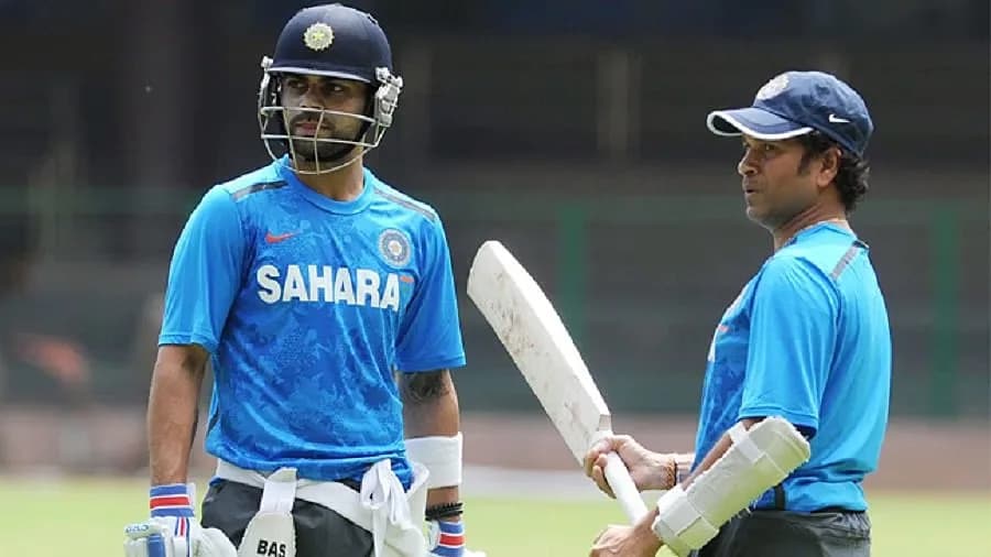 Virat Kohli raising his bat after reaching 15,000 ODI runs in a packed stadium