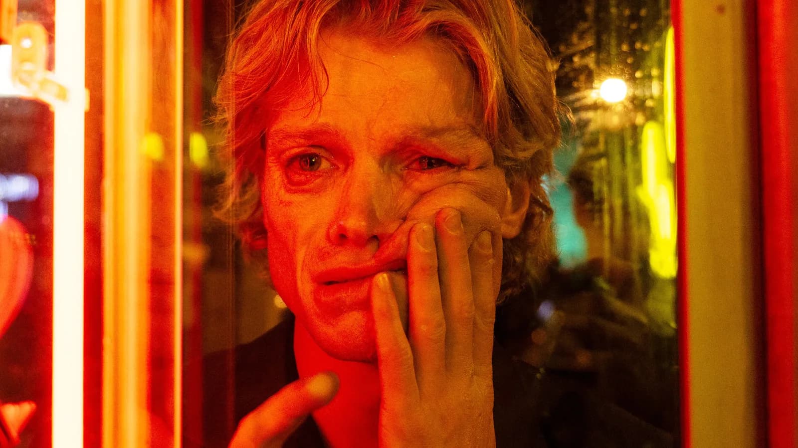 A close-up of a face made of shifting clay, half-formed, eyes glowing red.