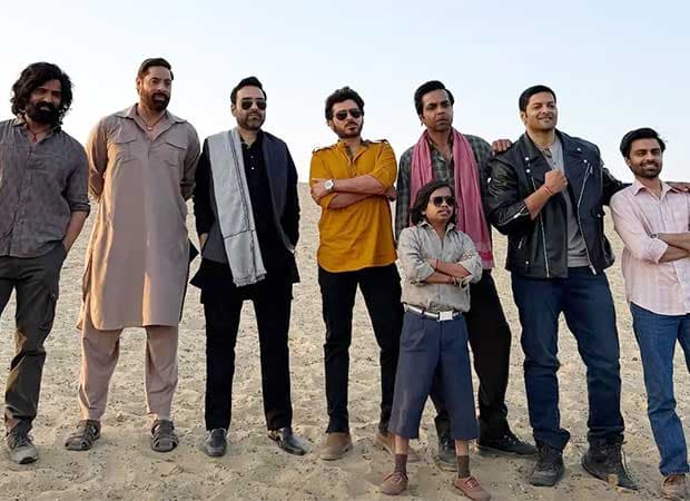 Pankaj Tripathi, Ali Fazal, Divyenndu and the Mirzapur cast pose together against a desert backdrop during behind-the-scenes filming.