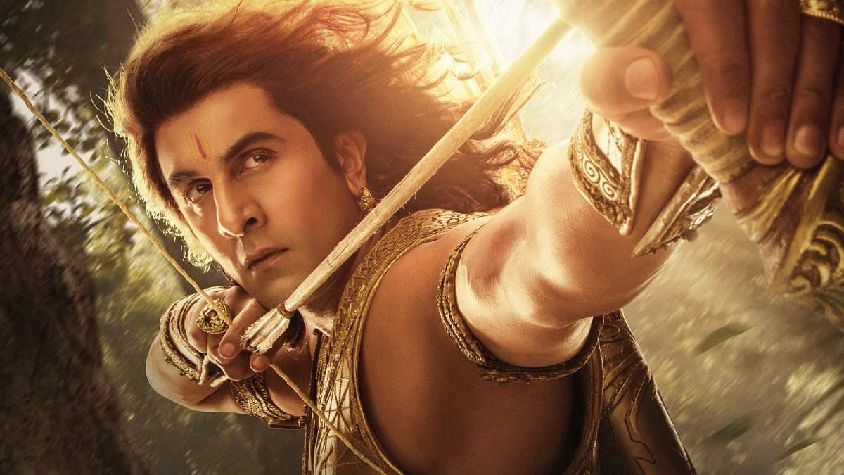Ranbir Kapoor as Lord Ram in a dramatic pose, standing amidst flames and storm clouds.