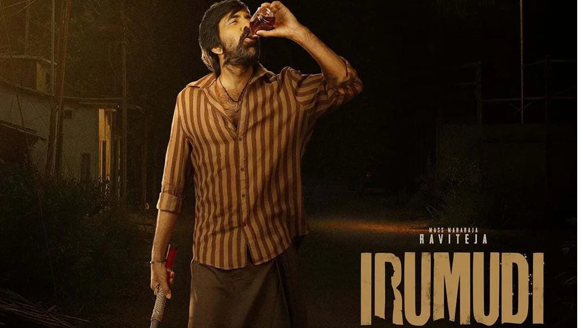 Ravi Teja standing beside the Irumudi poster with a Netflix logo in the background