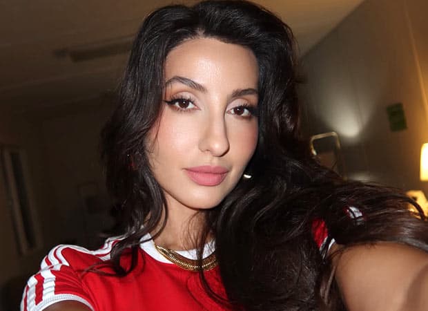 Nora Fatehi at a public event, smiling for photographers.