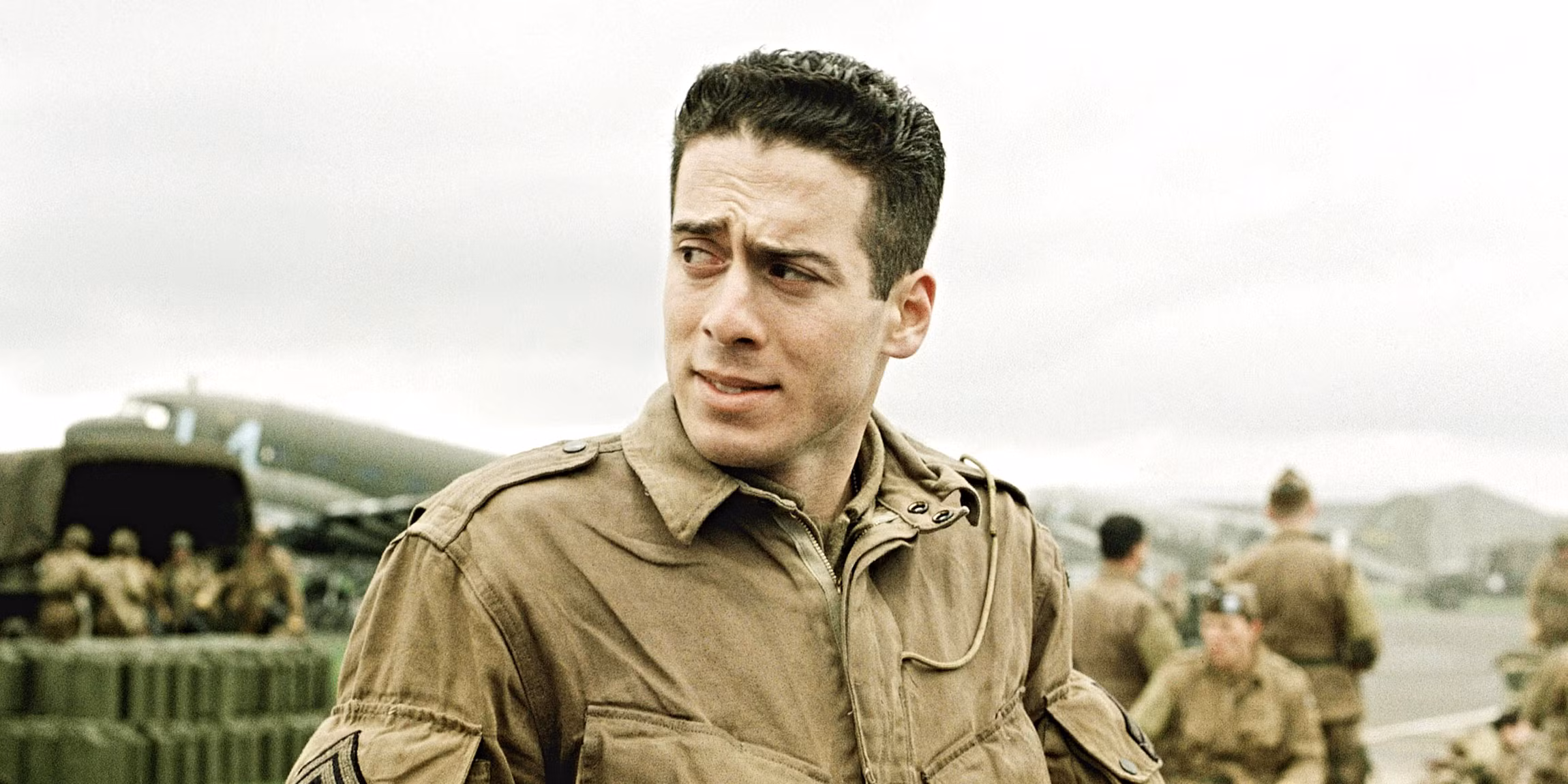 Soldiers in combat gear moving through a war-torn European village, a still evoking HBO's Band of Brothers.
