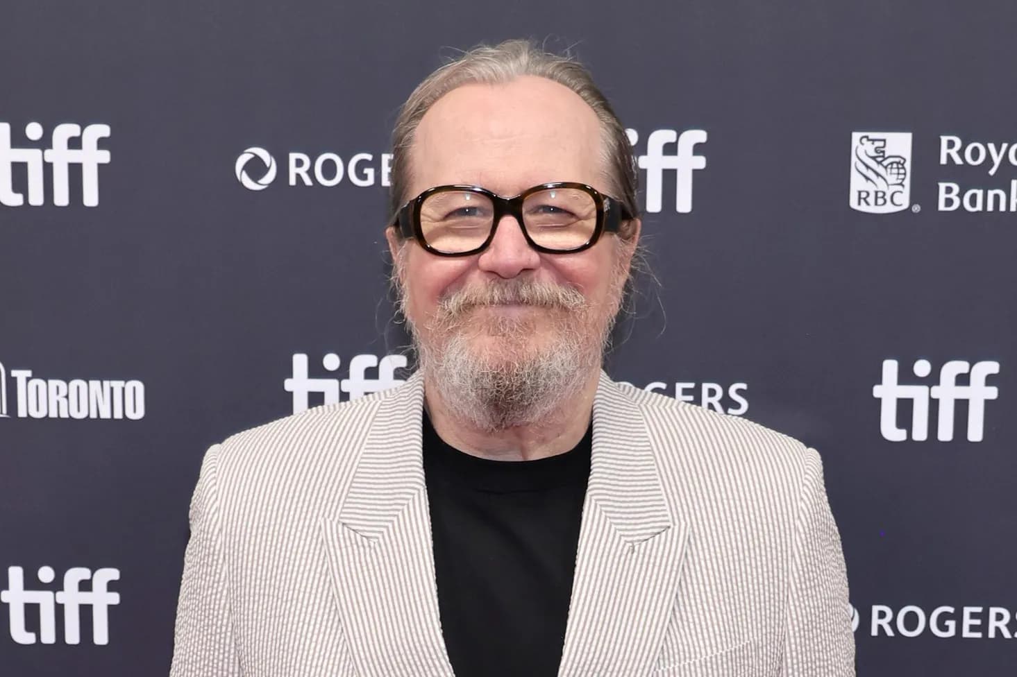 Gary Oldman in a dark suit during a television interview discussing HBO's Harry Potter series