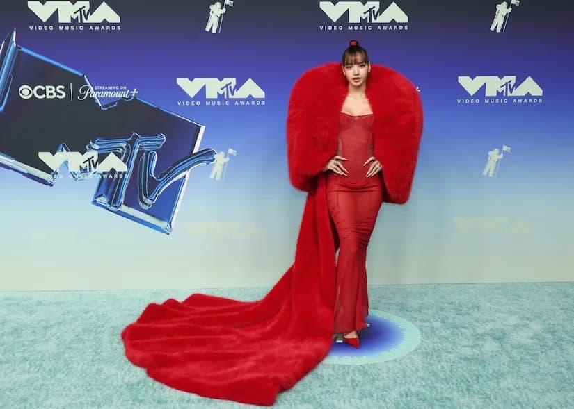 Lisa Rinna poses on the 2026 MTV VMAs red carpet in a sheer ivory gown with a thigh-high slit and a long train.