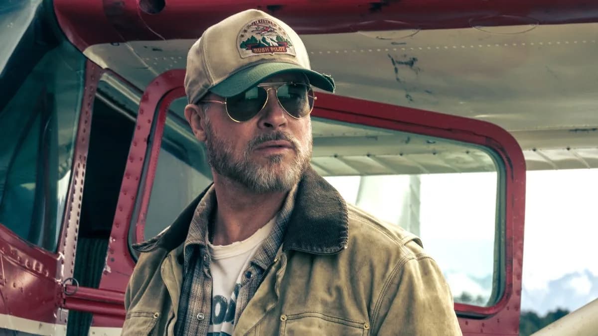Brad Pitt in a rugged outdoor setting, looking exhausted but determined.