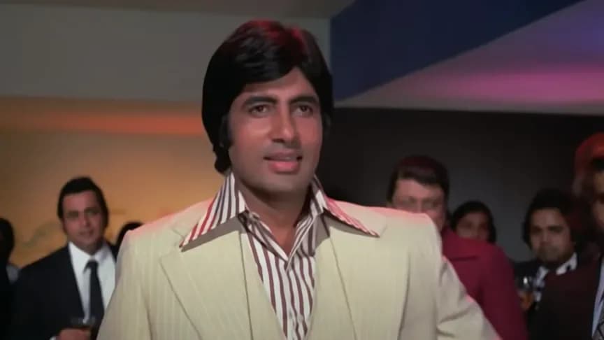 Amitabh Bachchan in a vintage photo from 'Deewaar', standing in a rain-soaked alley, looking intense.