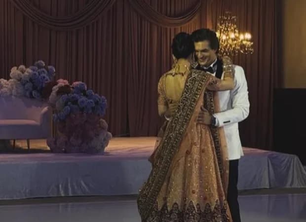 Mohsin Khan dancing with his bride Tamanna at their intimate California wedding, wearing a white tuxedo, she in a peach Anarkali suit.