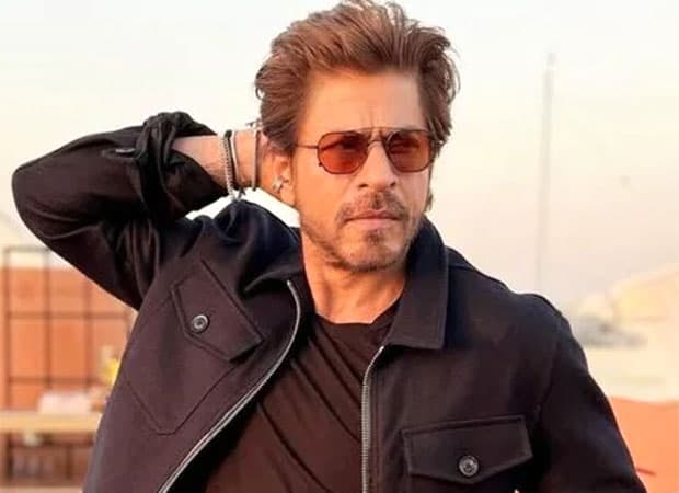 Shah Rukh Khan smiling at a public event, promotional image associated with his upcoming film King