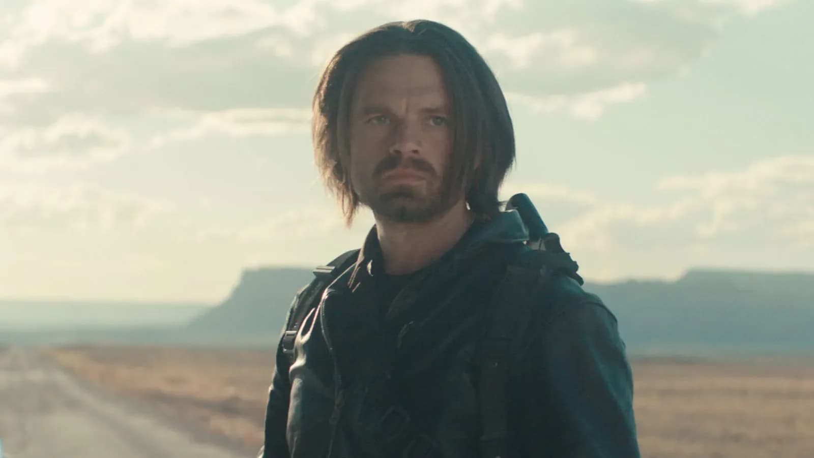 Sebastian Stan as Bucky Barnes in a dark, intense pose, standing against a fractured multiverse backdrop.