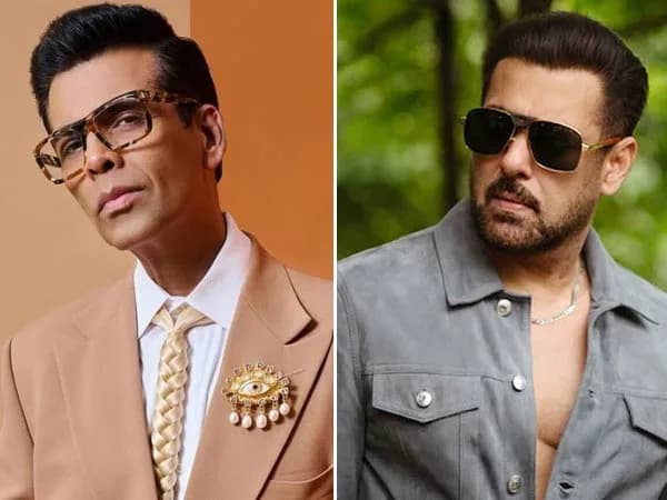 Karan Johar and Salman Khan sitting across from each other on a couch, smiling during a Koffee With Karan session.