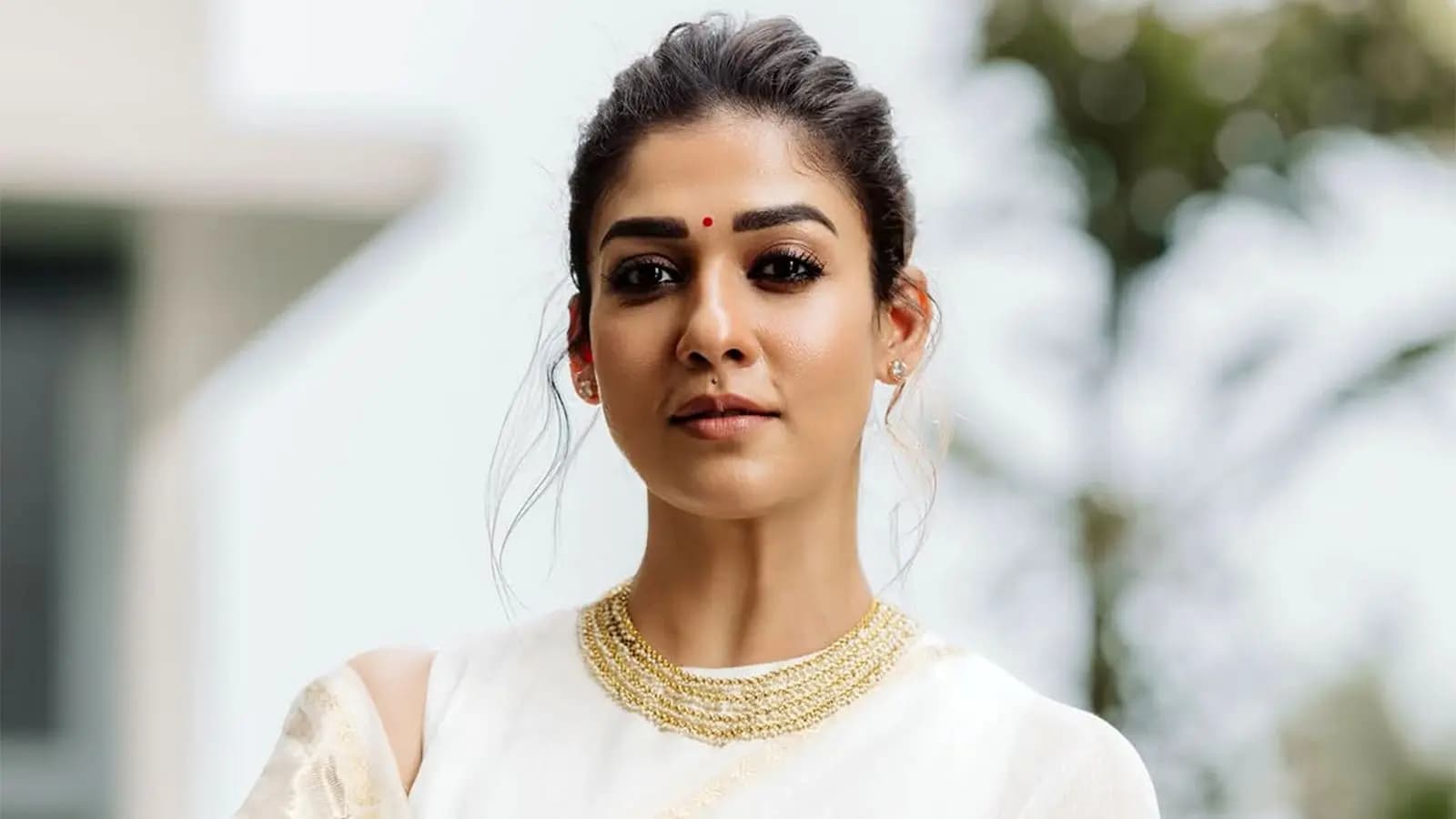 Nayanthara at a public event with her husband Vignesh Shivan, smiling at a crowd during a food distribution drive.