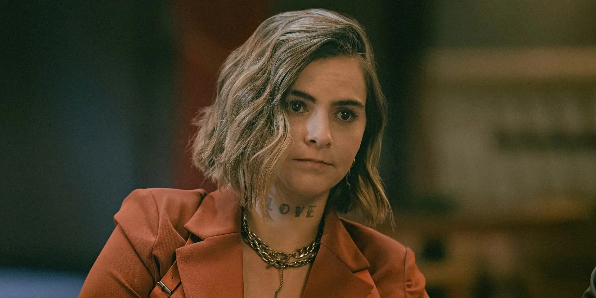Sylvester Stallone in a leather jacket, standing in front of a neon-lit Tulsa bar, looking down at a gun.