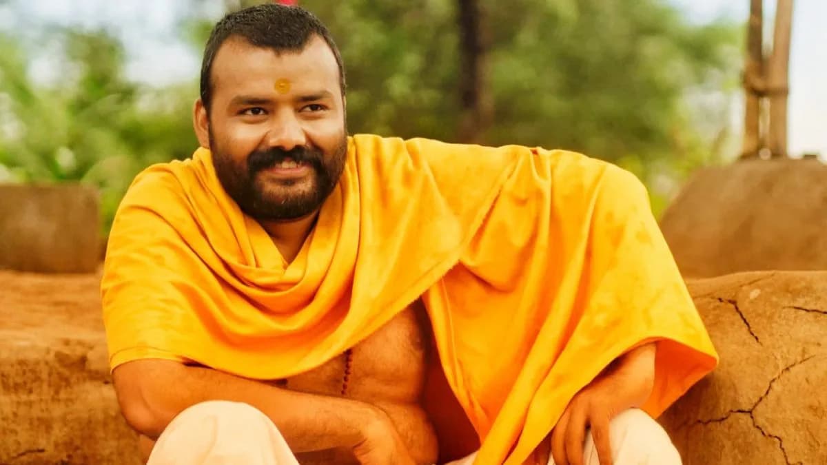 A still from Hanuman Ansh featuring Shobhinaw Satyaa in a devotional pose, surrounded by temple lights.