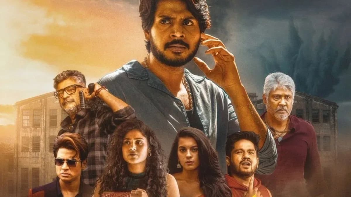 A still from the film Sigma showing Jason Sanjay standing beside Sandeep Kishan in a dramatic pose under dim lighting.
